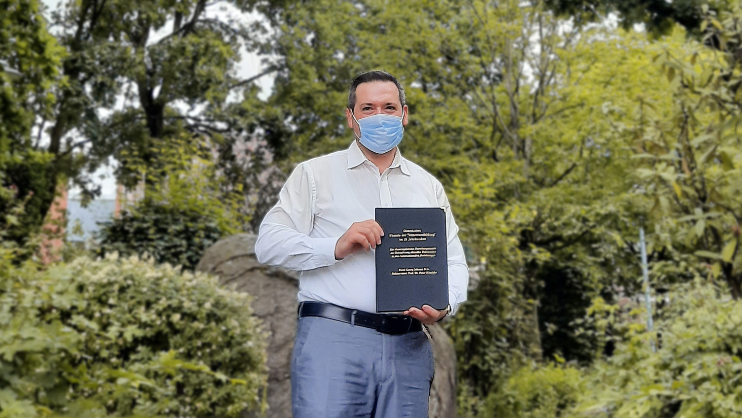 Leuphana-Alumni Rami Johann mit seiner Dissertation an der Uni Vechta.