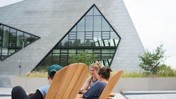 Studierende im Gespräch auf den Stühlen vor dem Zentralgebäude